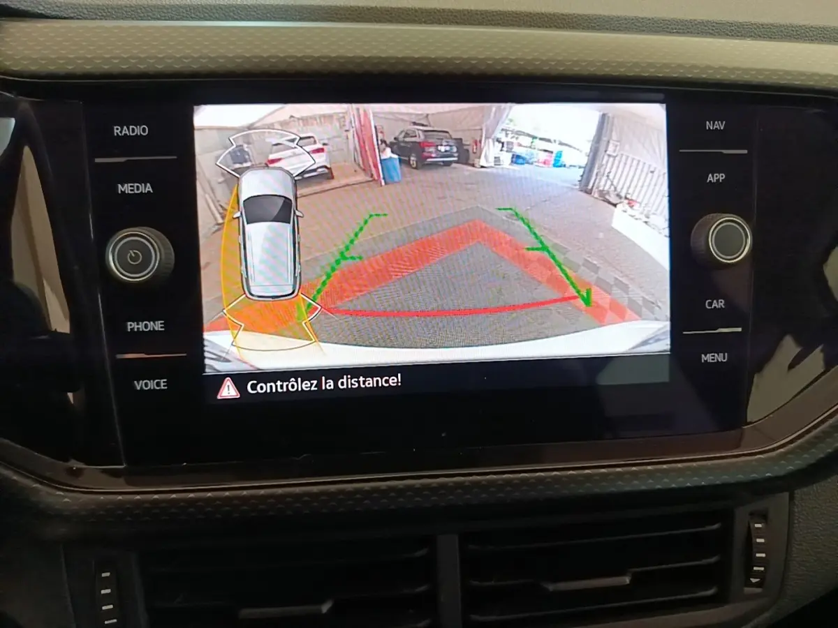 Écran tactile intérieur montrant la caméra de recul avec vue arrière et indication de distance de stationnement.