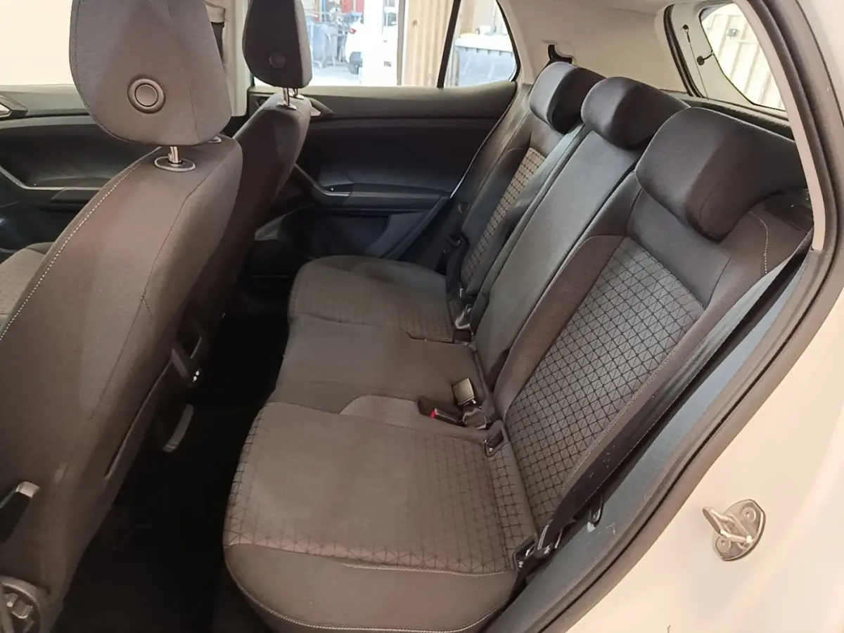 Vue intérieure côté droit montrant la banquette arrière noire du Volkswagen T-Cross blanc 2022.