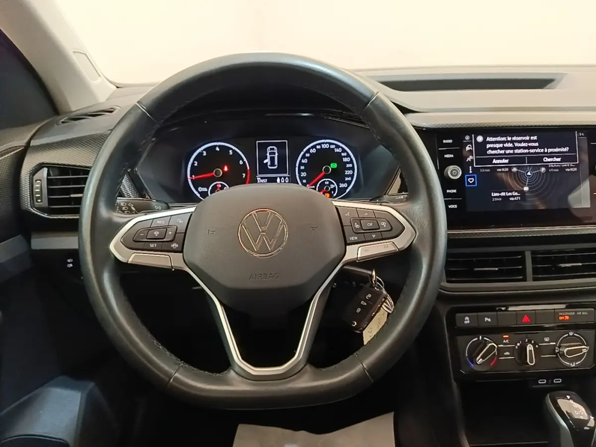 Vue intérieure centrée sur le volant cuir multifonctions et le tableau de bord numérique du Volkswagen T-Cross blanc 2022.