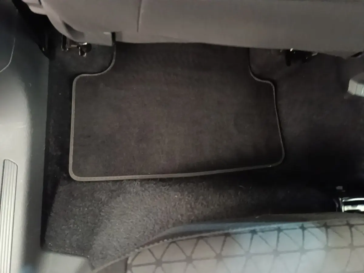 Vue intérieure du tapis de sol noir côté passager avant du Volkswagen T-Cross blanc 2022.