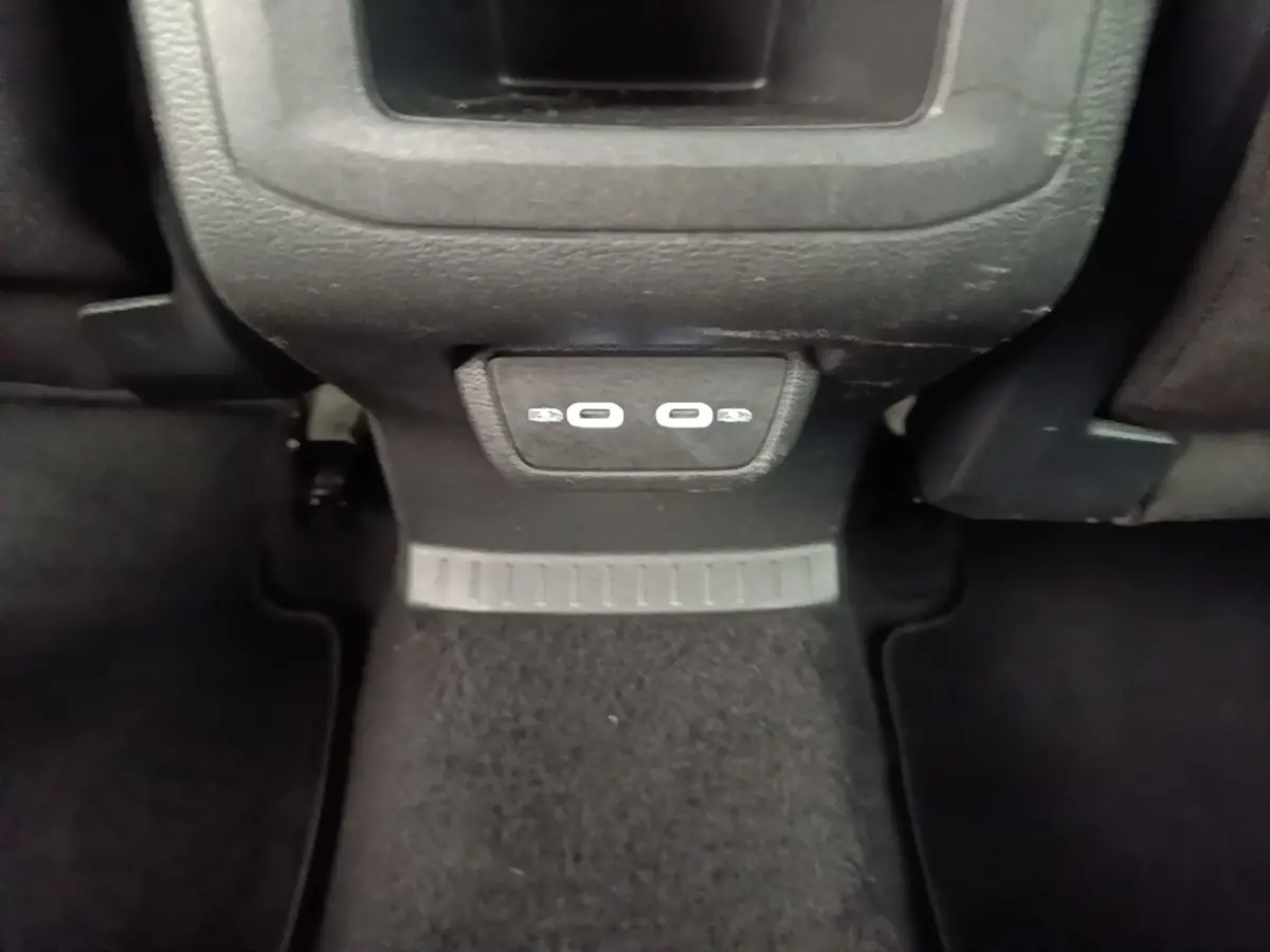Vue rapprochée des ports USB arrière sur la console centrale noire du Volkswagen T-Cross blanc 2022.