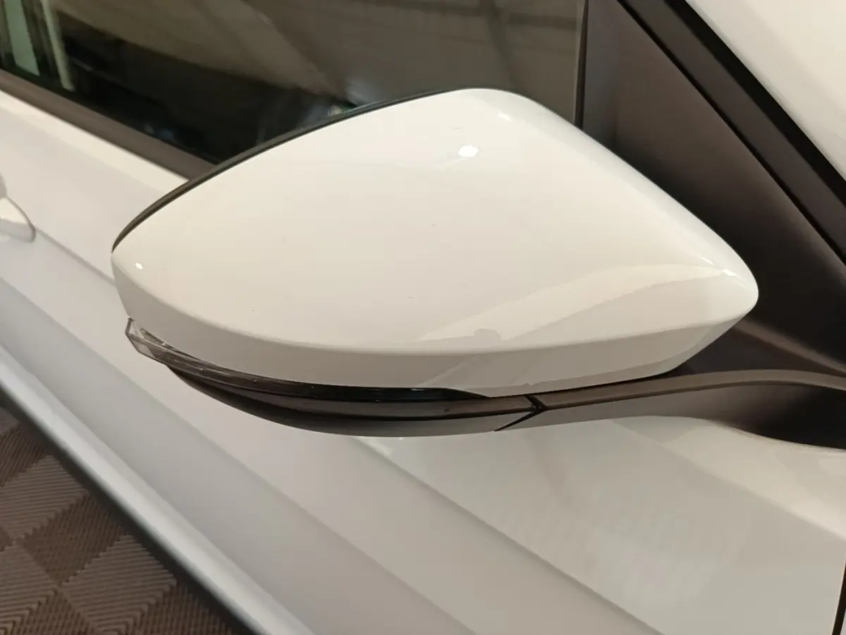 Rétroviseur droit blanc du Volkswagen T-Cross 2022, avec clignotant intégré, vue rapprochée côté extérieur.