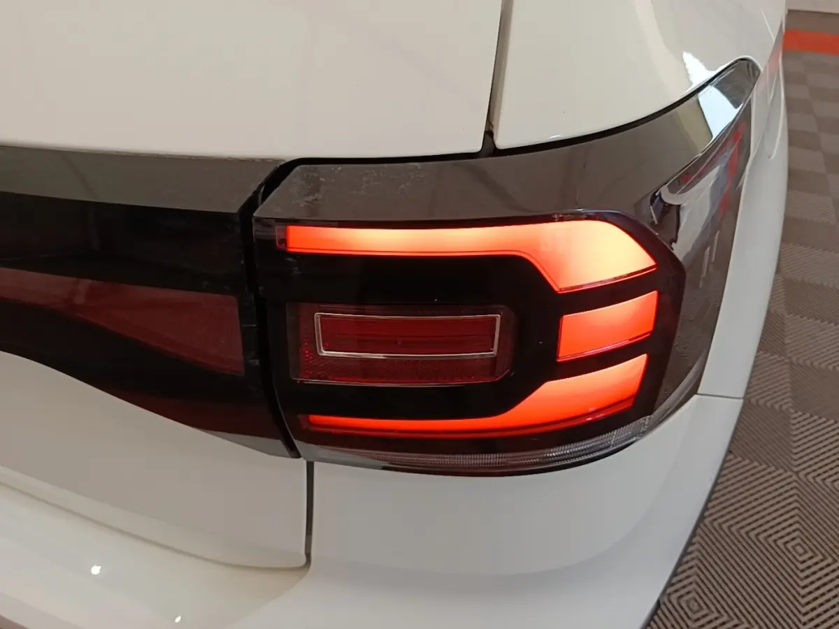 Gros plan sur le feu arrière droit rouge et noir du Volkswagen T-Cross blanc, version 2022 essence.