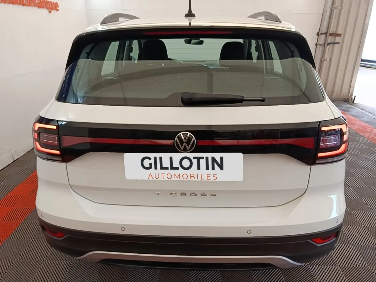 Vue arrière d'un Volkswagen T-Cross blanc 2022 avec feux arrière LED et logo central sur hayon noir brillant.