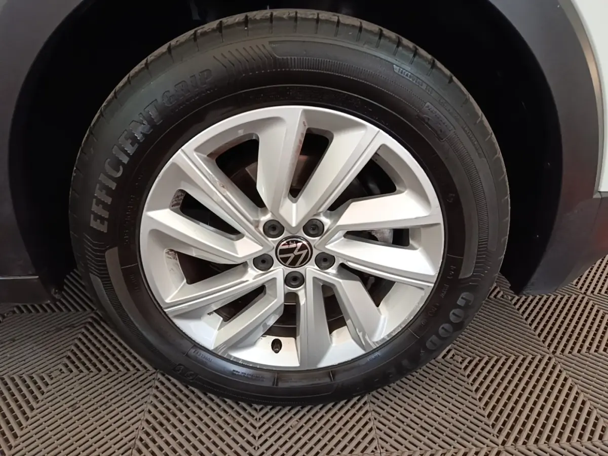 Gros plan sur la jante alliage argentée et le pneu Goodyear d'un Volkswagen T-Cross blanc, côté droit.