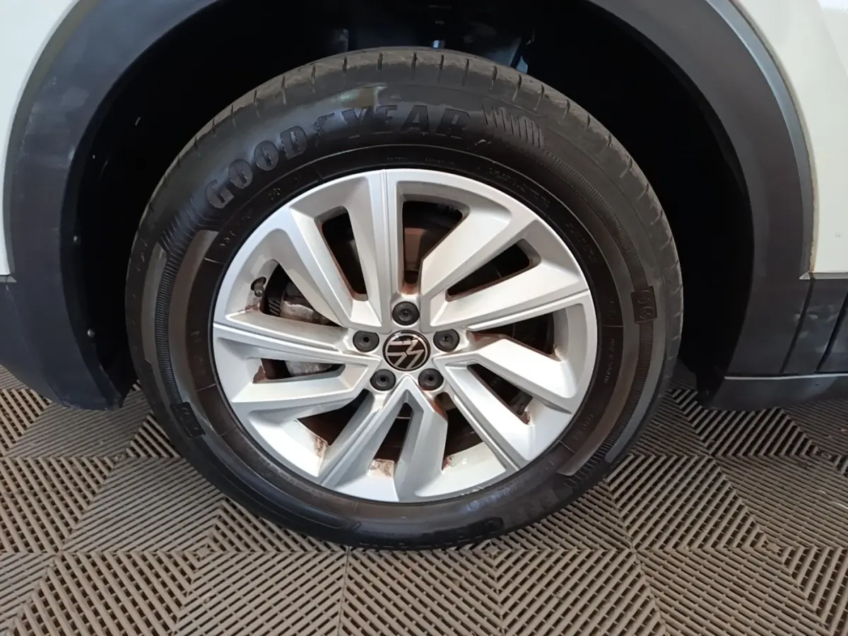 Gros plan sur la roue avant droite blanche d’un Volkswagen T-Cross 2022 avec jante alliage et pneu Goodyear.