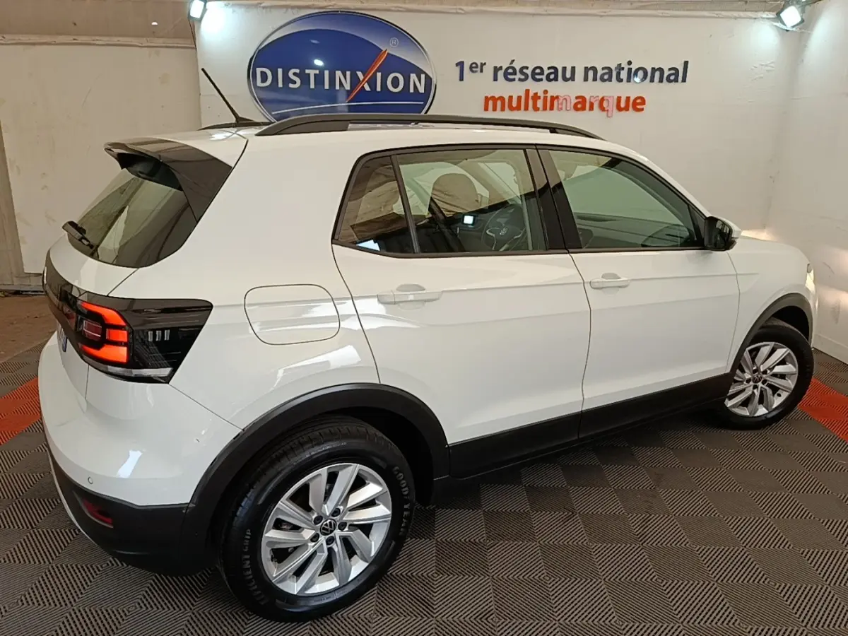 Volkswagen T-Cross blanc vue 3/4 arrière côté droit, feux arrière LED et jantes alliage visibles.