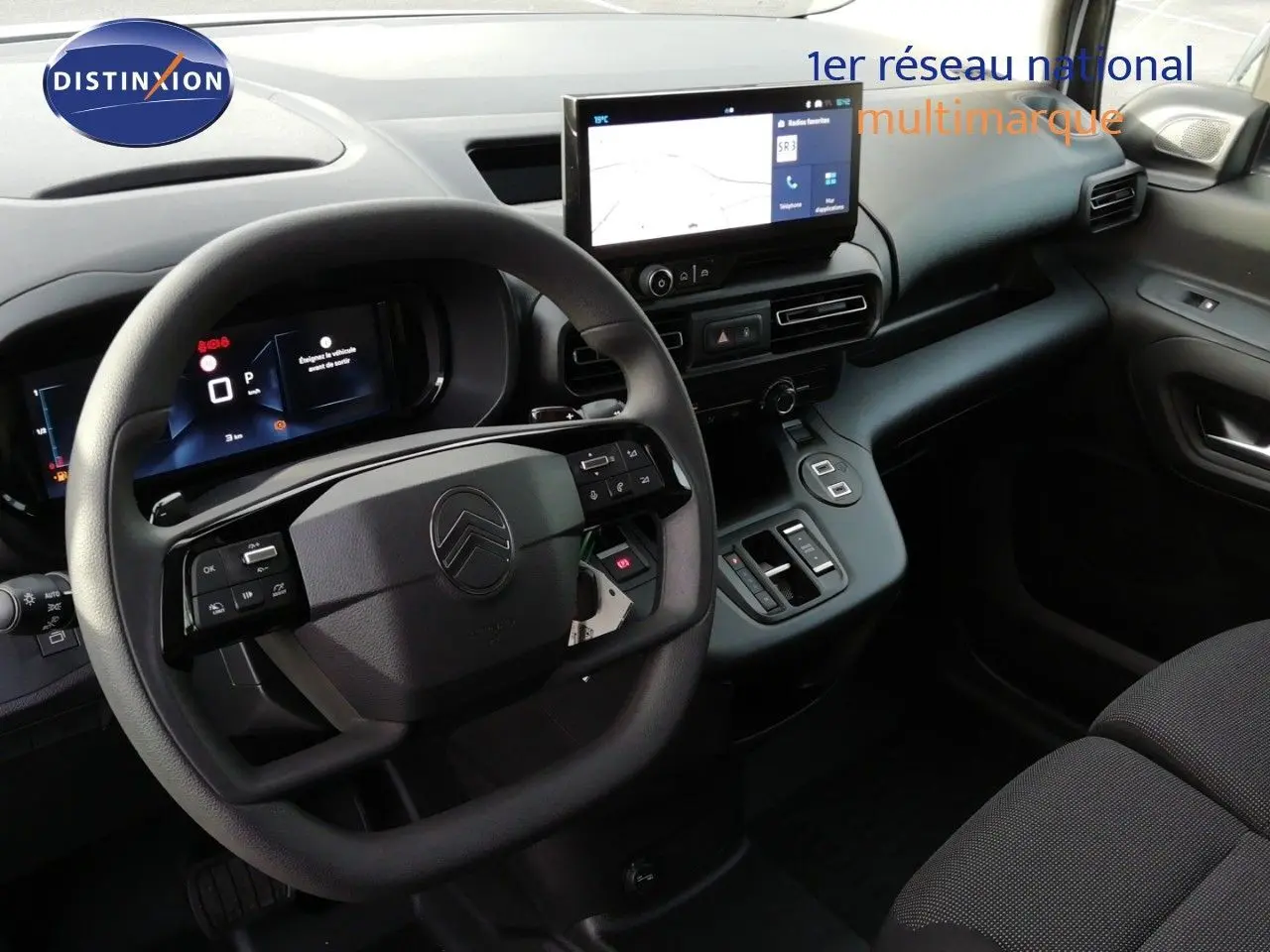 Vue intérieure côté conducteur du Citroën Berlingo XL 2026, tableau de bord noir avec écran tactile central et volant multifonctions.