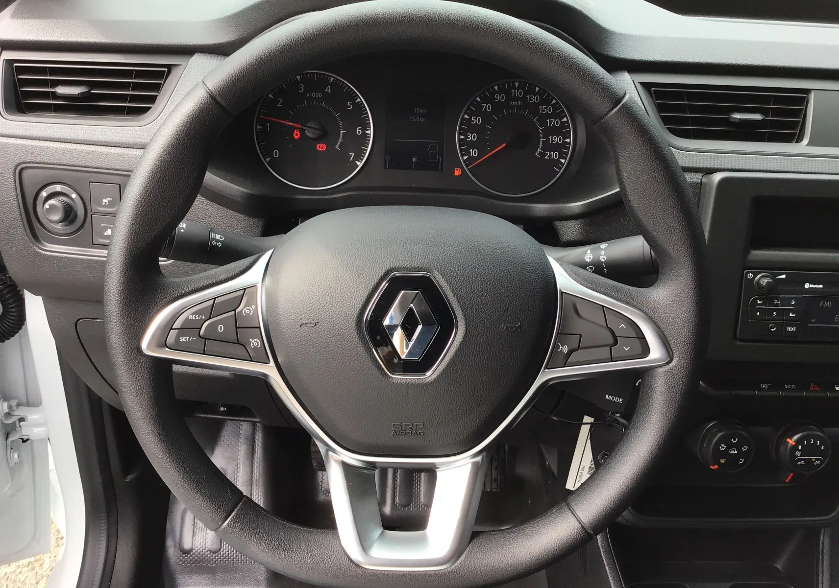 Vue rapprochée du volant noir du Renault Express Van blanc 2024, avec tableau de bord et commandes visibles.