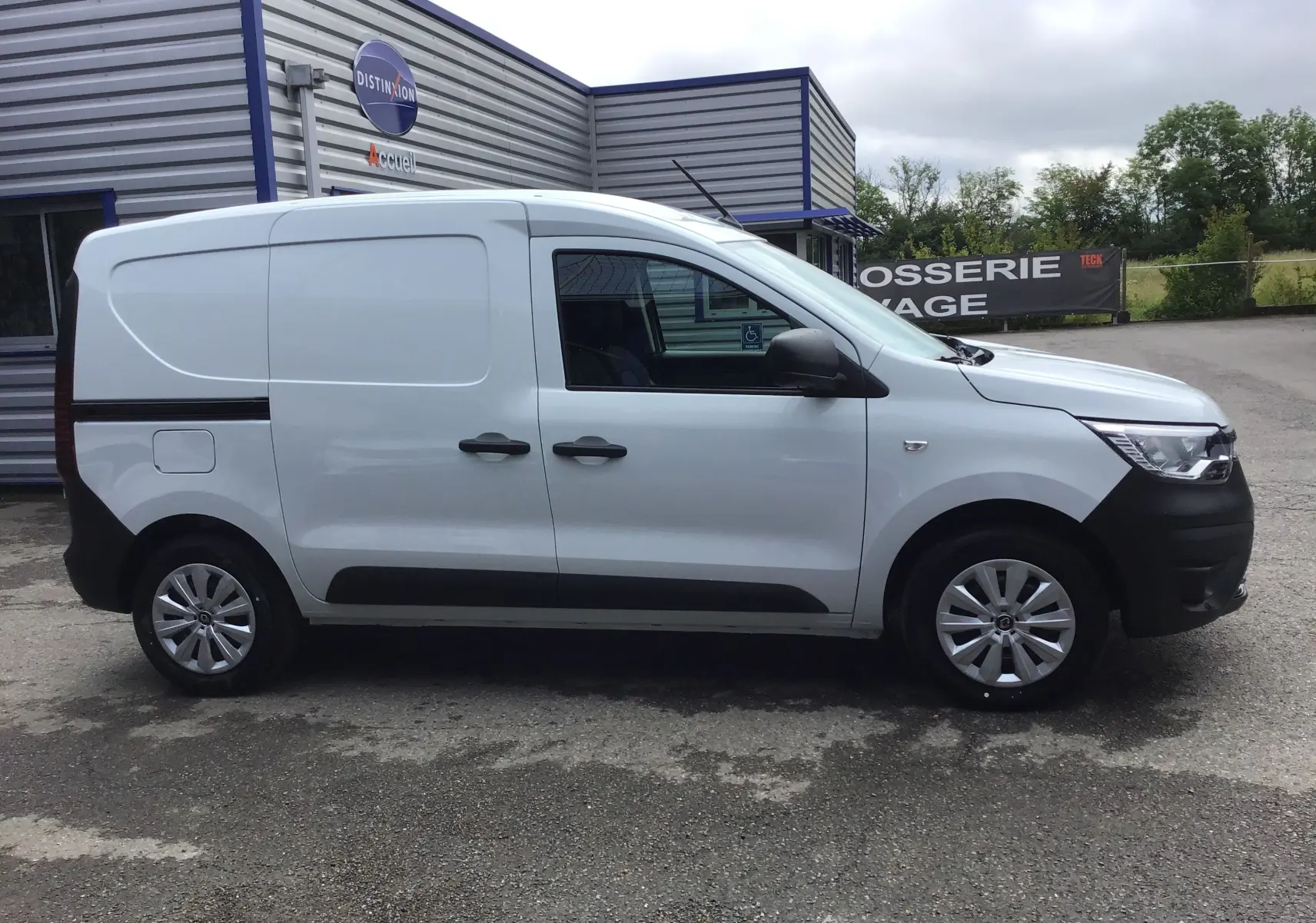 Vue de profil côté droit d'un Renault Express Van blanc 2024 avec protections noires sur les pare-chocs et bas de caisse.