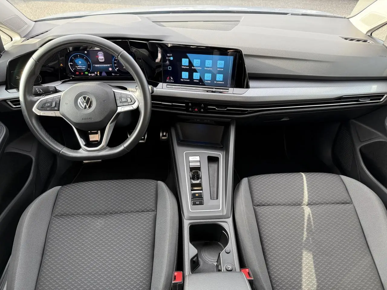 Vue intérieure avant de la Volkswagen Golf VIII Life Active avec tableau de bord digital et volant multifonction cuir.