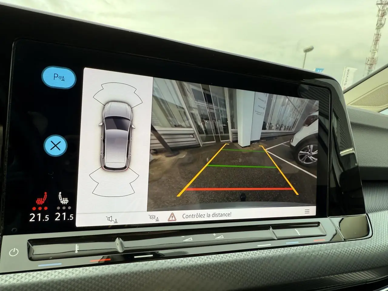 Écran de caméra de recul et capteurs de stationnement d'une Volkswagen Golf argent métallisé, vue intérieure avant.