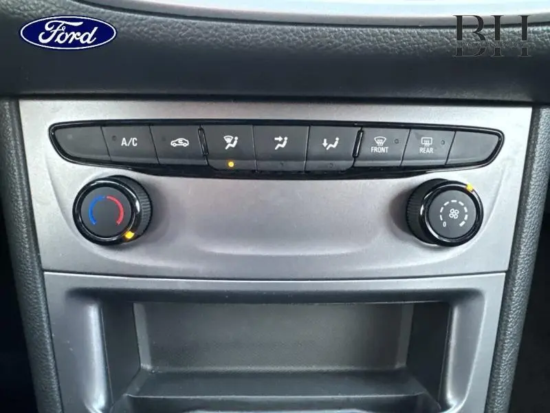 Vue rapprochée de la console centrale avec commandes de climatisation et ventilation sur Opel Astra gris Mineral.