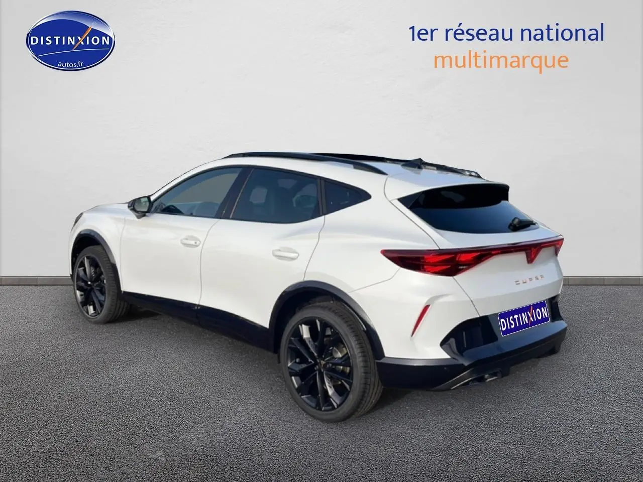 Vue 3/4 arrière droite d'un CUPRA Formentor blanc Nevada avec jantes noires et toit ouvrant panoramique.