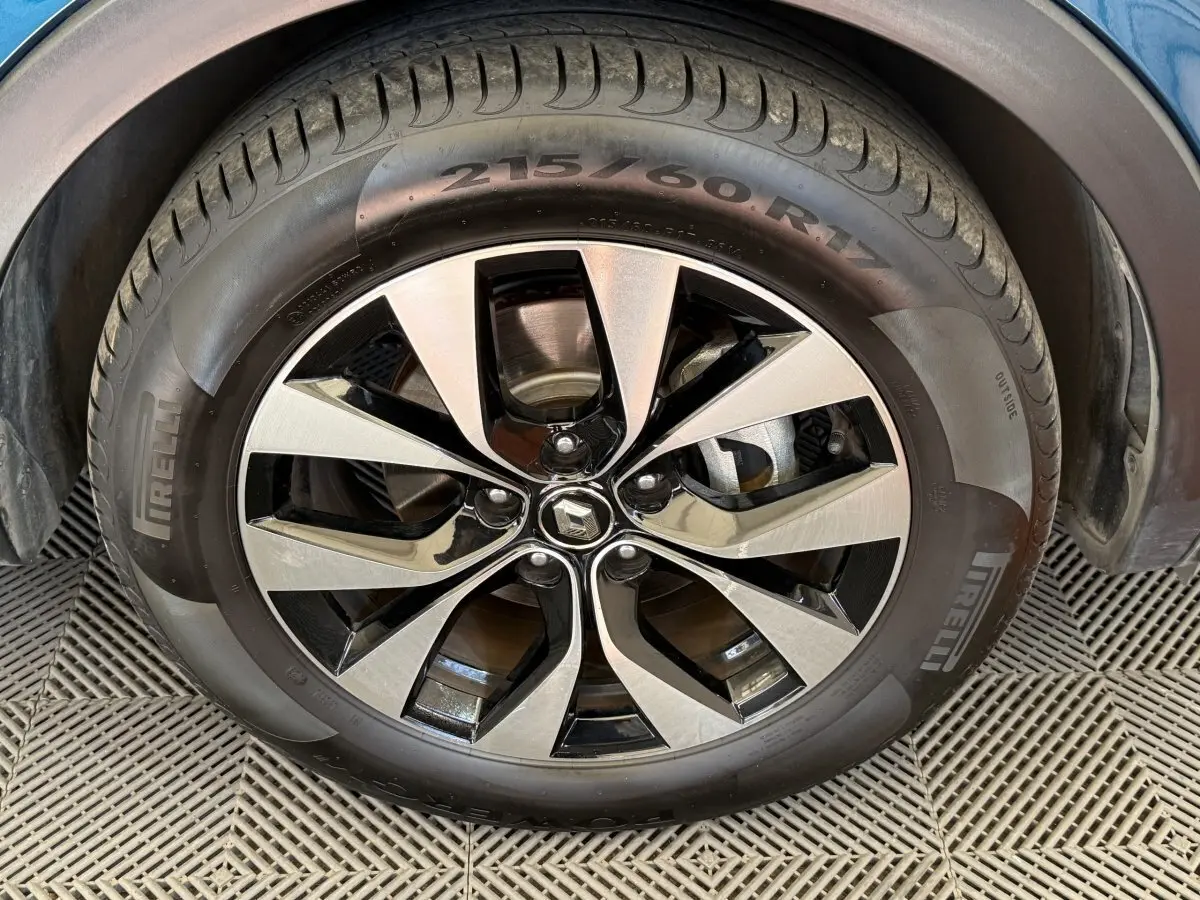 Gros plan sur la roue avant droite du Renault Arkana Business E-TECH 145 bleu avec jante alliage bicolore.