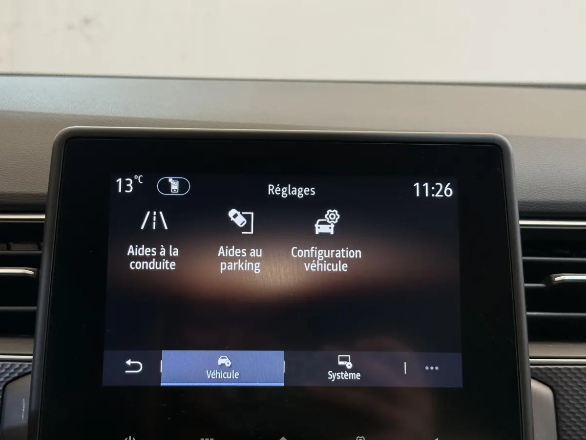 Écran tactile central affichant les réglages du véhicule Renault Arkana Business E-TECH 145, vue frontale intérieure.