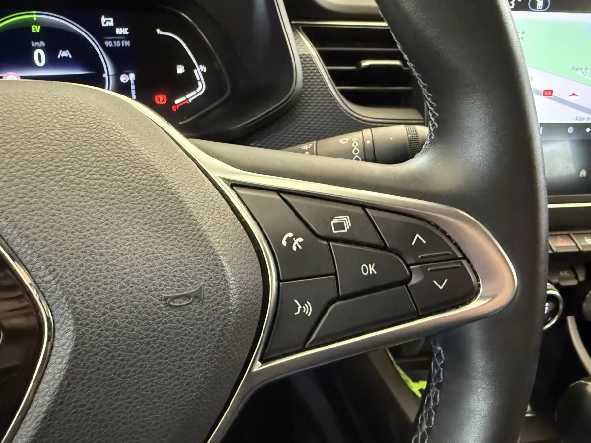 Gros plan sur le volant cuir et alu du Renault Arkana Business E-TECH 145 avec commandes multifonctions visibles.