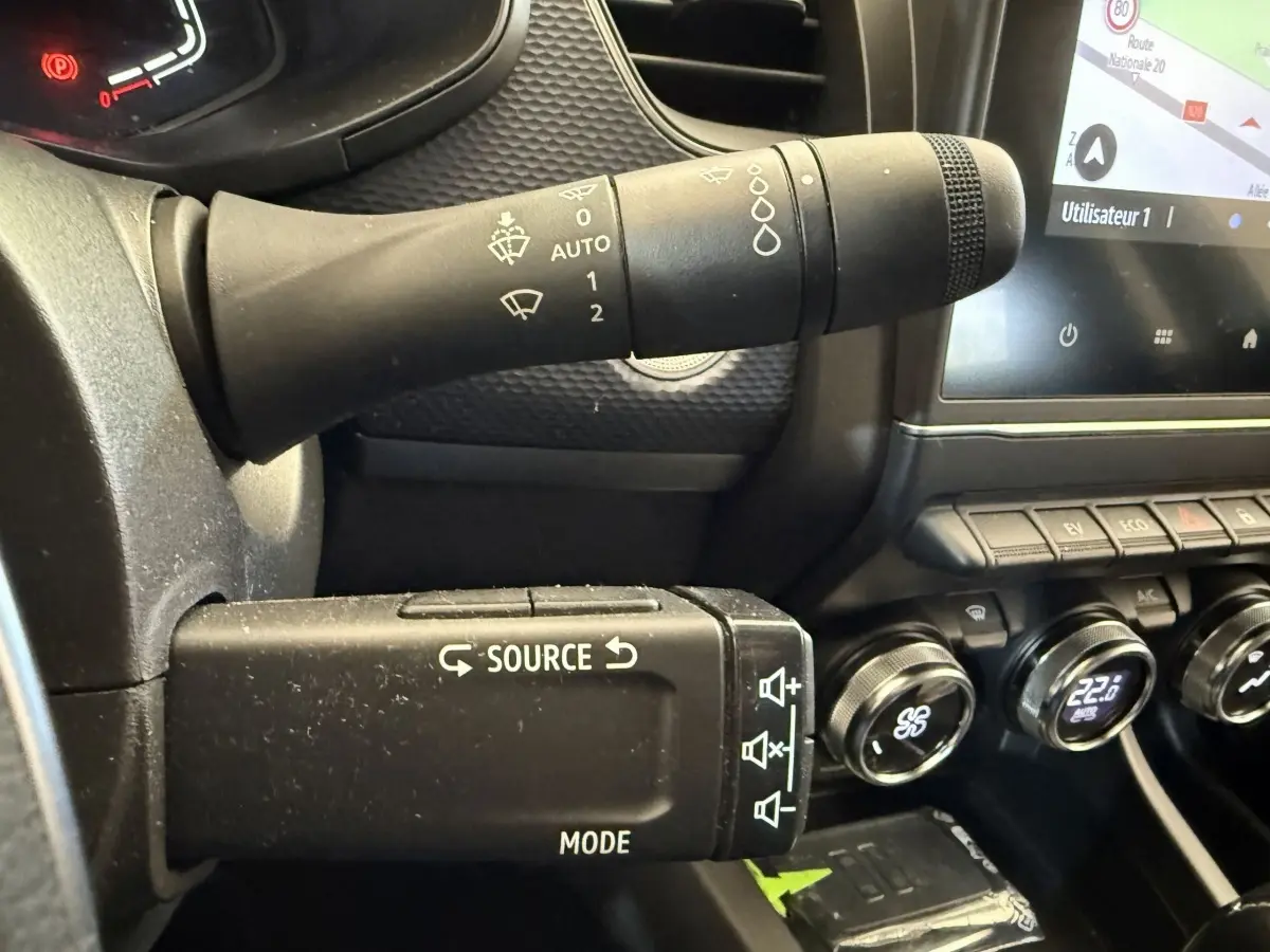 Gros plan sur la commande multimédia et les commandes d’essuie-glace du tableau de bord noir du Renault Arkana Business E-TECH 145.