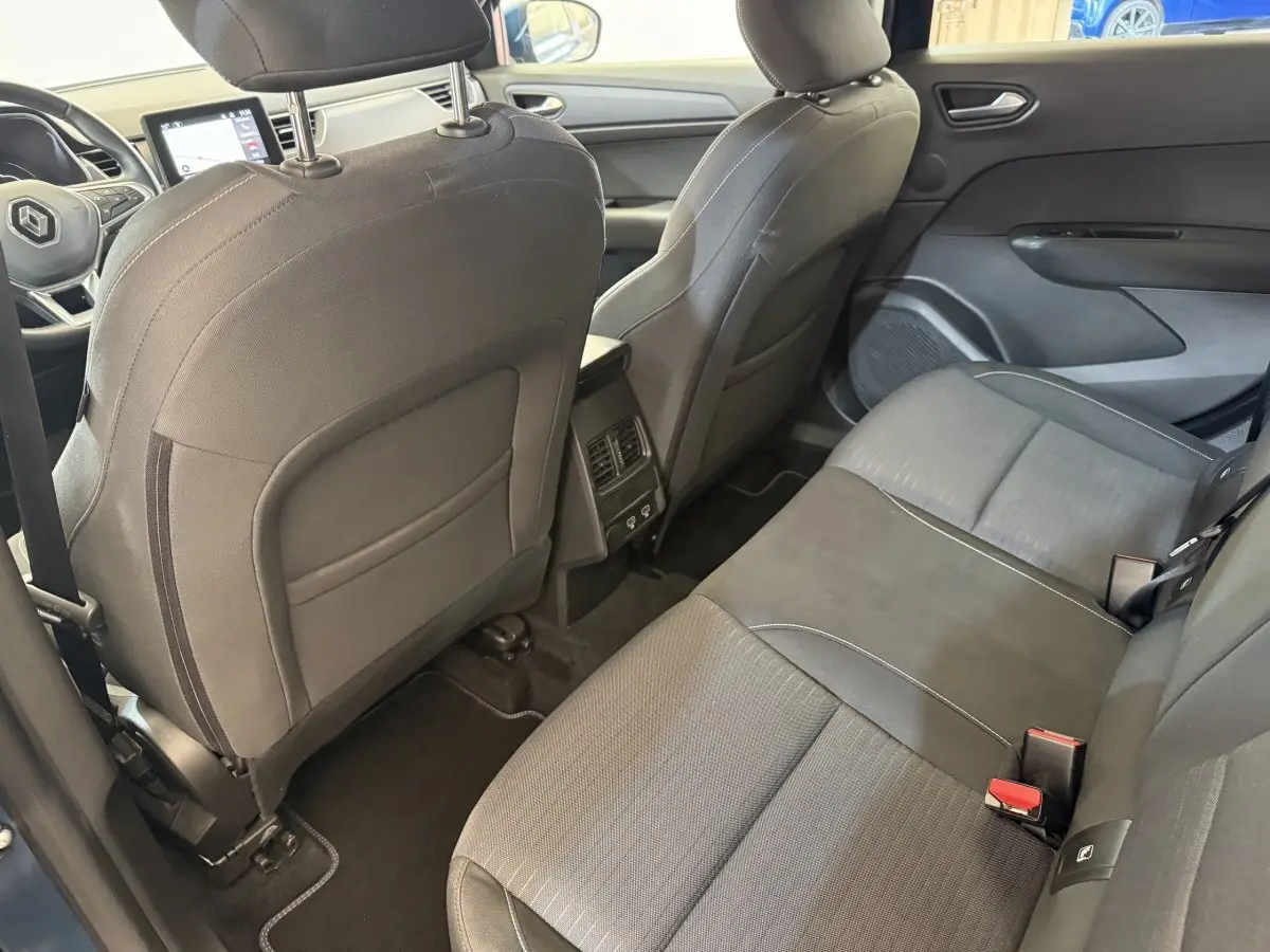 Vue intérieure arrière droite sur la banquette noire et les sièges avant du Renault Arkana Business E-TECH 145 2022.