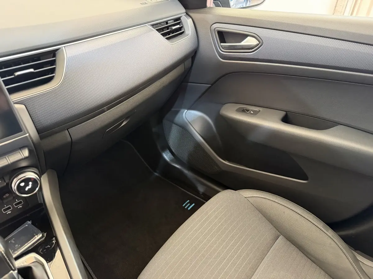 Vue intérieure côté passager avant du Renault Arkana Business E-TECH 145, avec sellerie grise et panneaux de porte noirs.