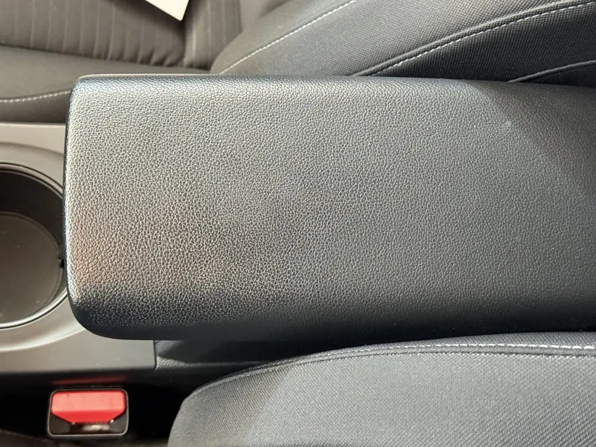 Gros plan sur l'accoudoir central noir en cuir synthétique de l'habitacle du Renault Arkana Business E-TECH 145.