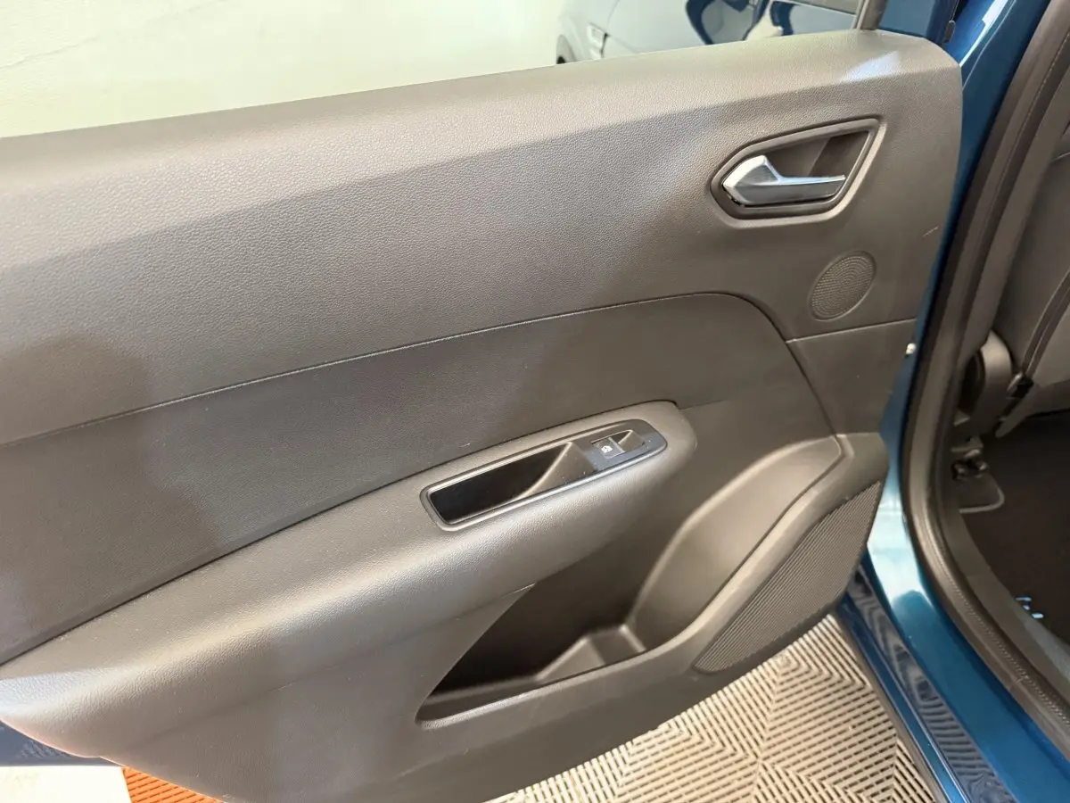 Vue intérieure côté gauche de la porte arrière bleu Renault Arkana Business E-TECH avec commande de vitre et haut-parleur intégré.