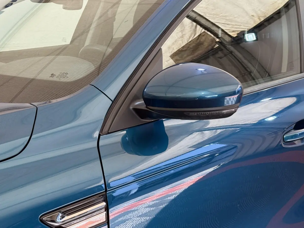 Gros plan sur le rétroviseur côté conducteur bleu métallisé du Renault Arkana Business E-TECH 145 2022.