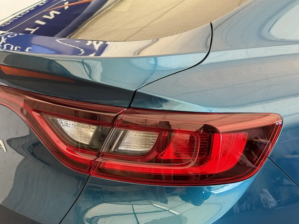 Gros plan sur le feu arrière droit rouge du Renault Arkana Business E-TECH 145 bleu 2022, avec spoiler de coffre visible.