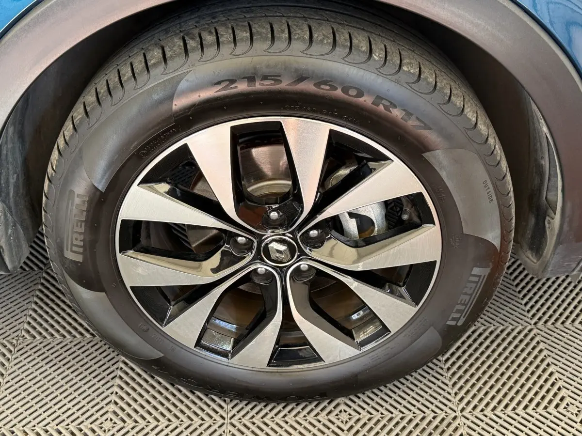 Gros plan sur la jante alu bicolore et le pneu Pirelli d'une Renault Arkana Business E-TECH bleu 2022.