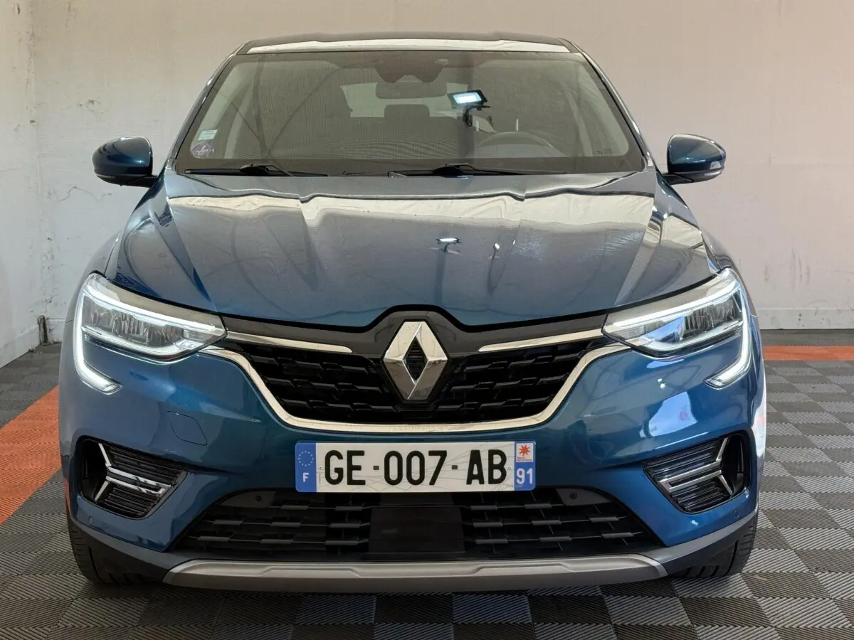 Vue frontale d'une Renault Arkana Business E-TECH 145 bleu avec calandre noire et feux LED distinctifs.