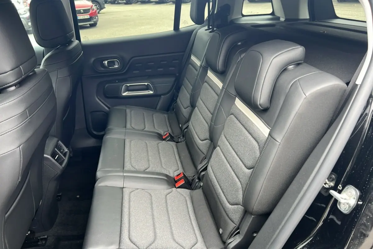 Vue intérieure côté droit des trois sièges arrière individuels gris foncé du Citroën C5 Aircross Hybrid 2025 noir.