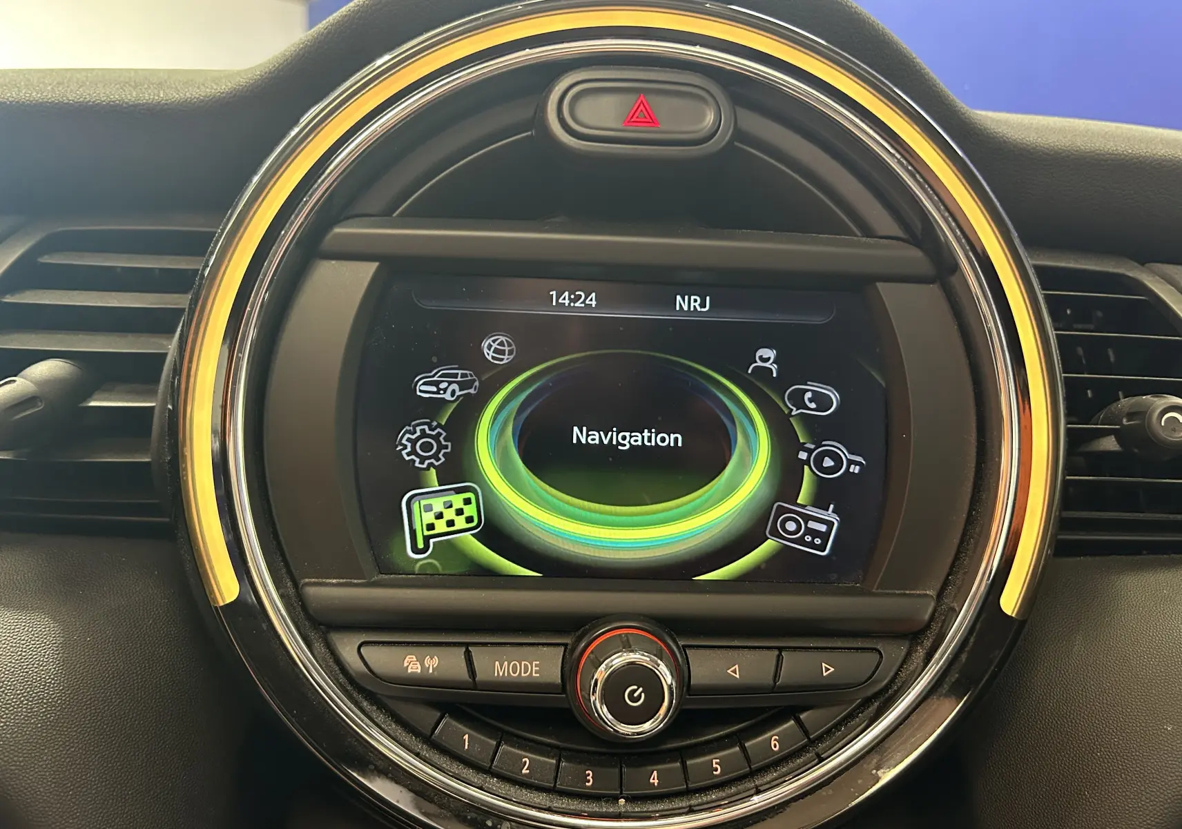 Gros plan sur l’écran central rond de la MINI 5P Cooper D 2015, affichant le menu navigation avec éclairage ambre.