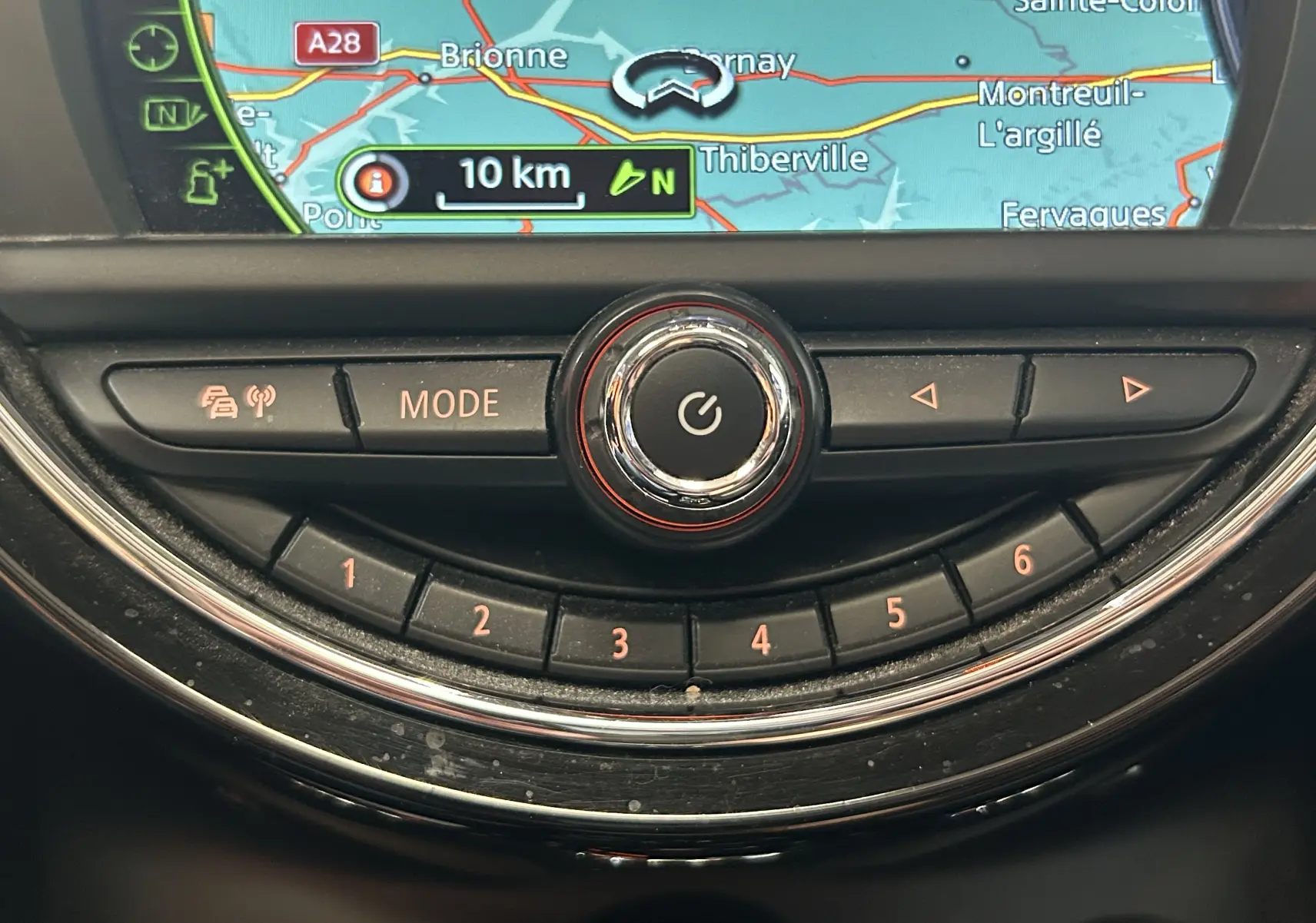 Gros plan sur la console centrale de la MINI 5P Cooper D 2015, avec écran GPS et commandes circulaires rétroéclairées.