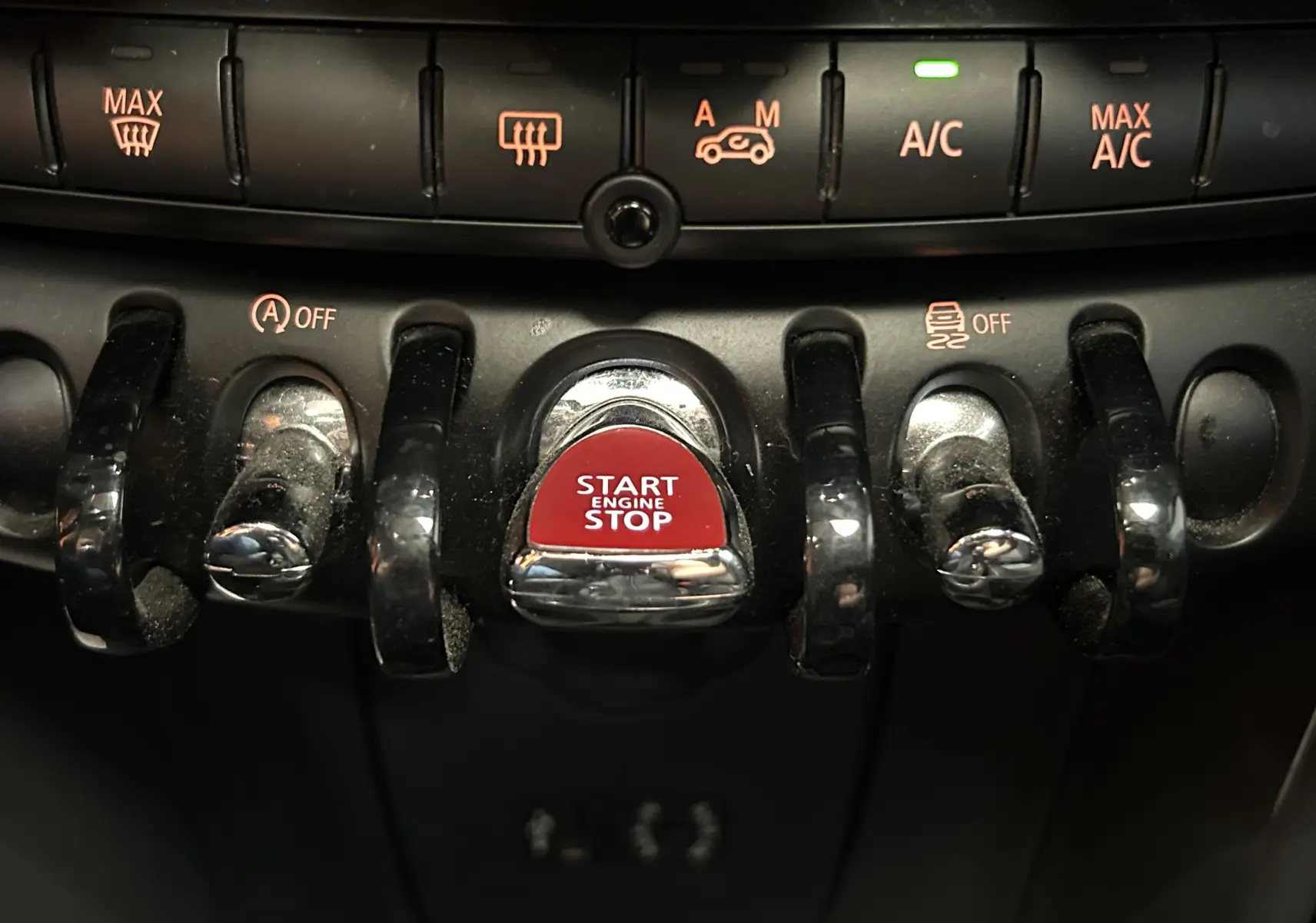 Gros plan sur les commandes centrales d'une MINI 5P Cooper D 2015, avec bouton rouge Start Engine Stop au centre.