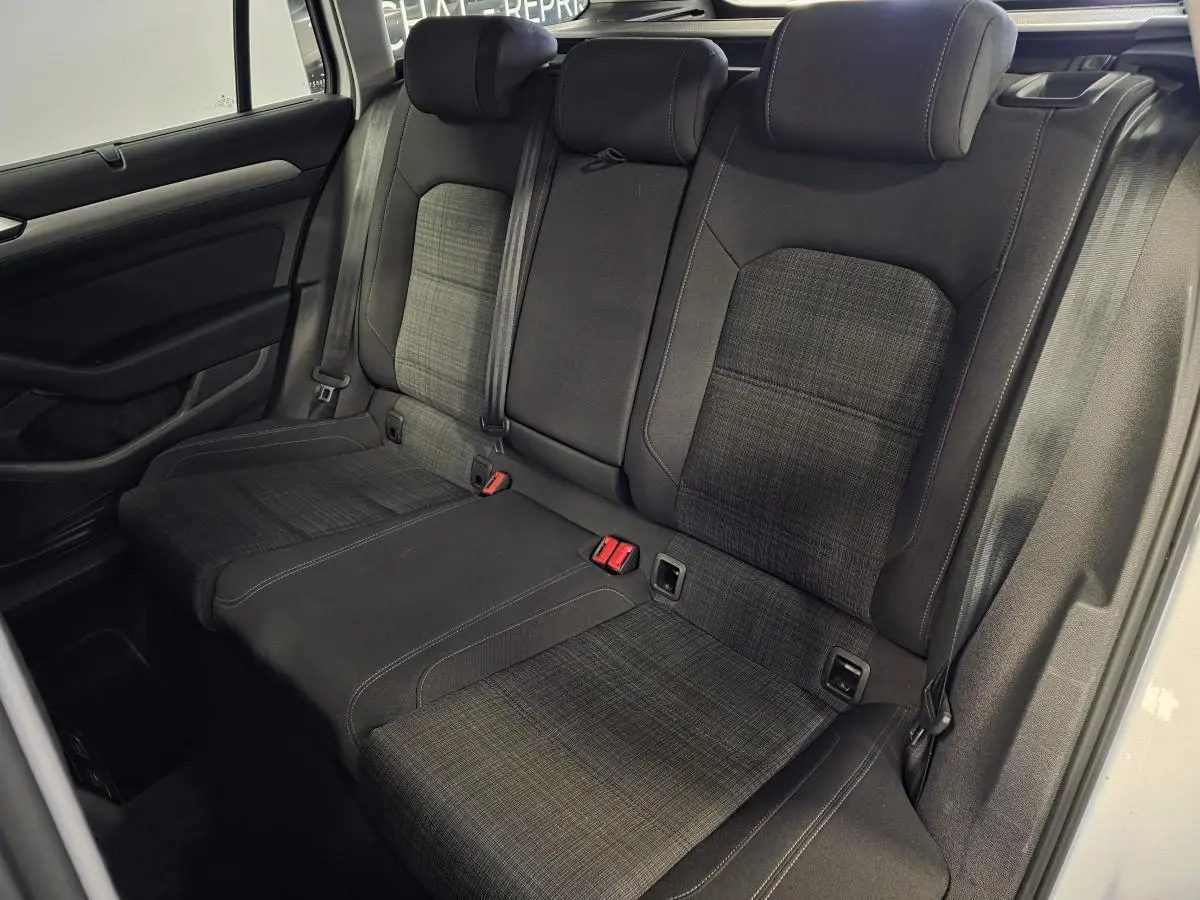 Vue intérieure côté arrière droit de la banquette tissu gris foncé avec appuie-têtes et ceintures de sécurité de la Volkswagen Passat SW 2021.
