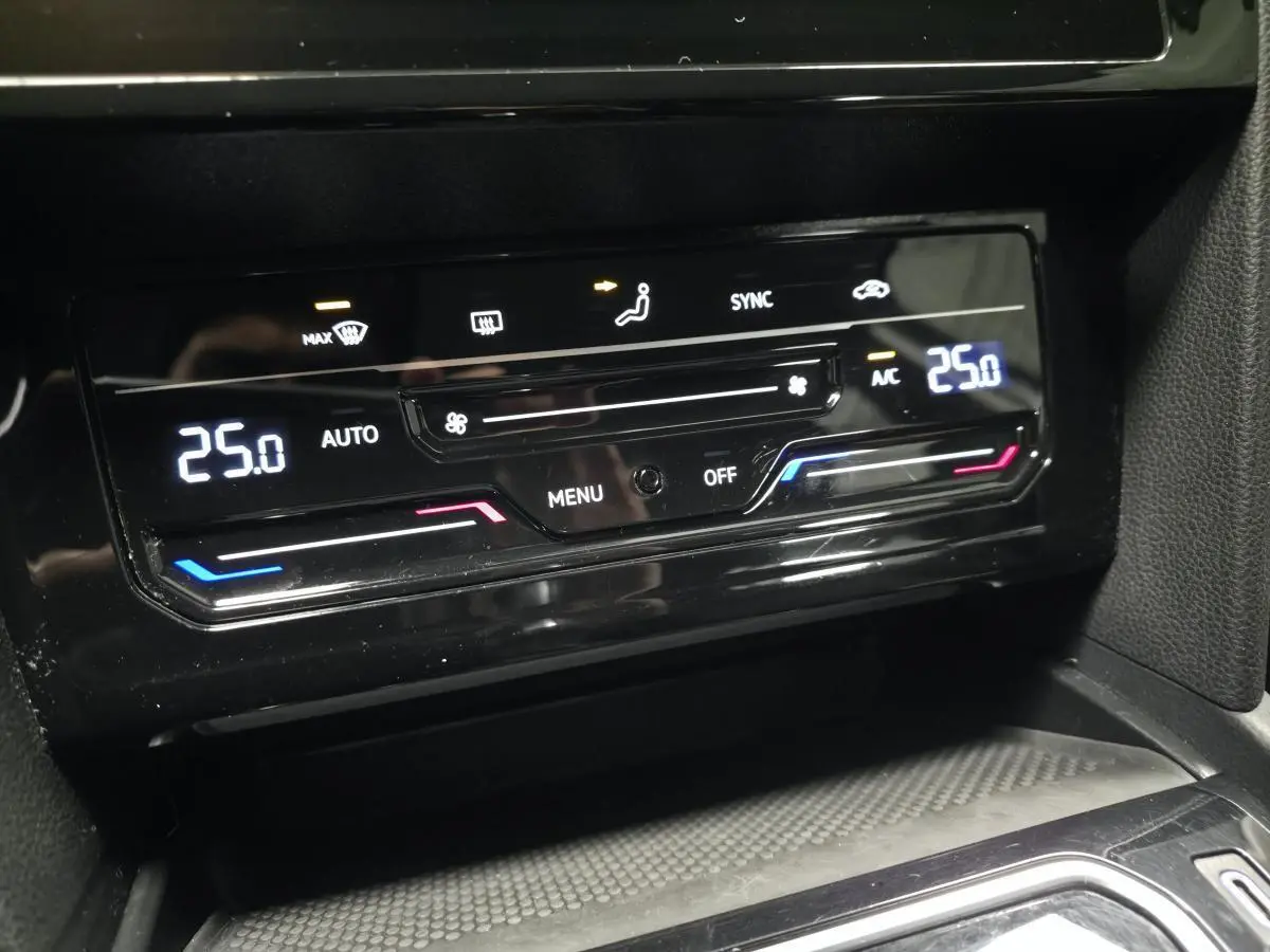 Détail de la console centrale de la Volkswagen Passat SW 2021, affichage numérique de la climatisation à 25°C.