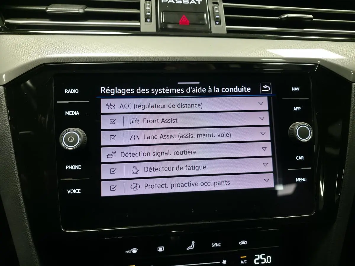Écran tactile central de la Volkswagen Passat SW 2021 affichant les réglages des aides à la conduite.