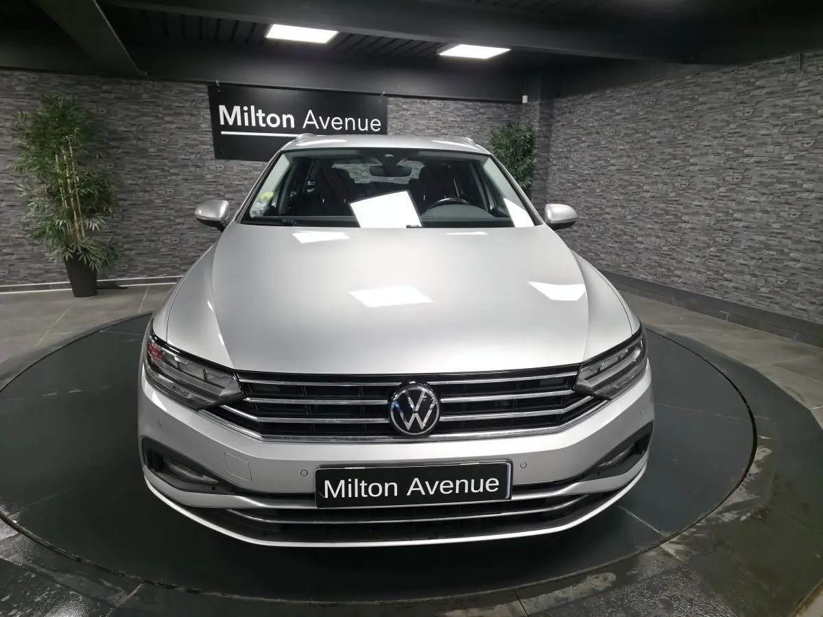 Vue avant d'une Volkswagen Passat SW gris métallisé 2021 avec calandre chromée et logo VW bien visible.