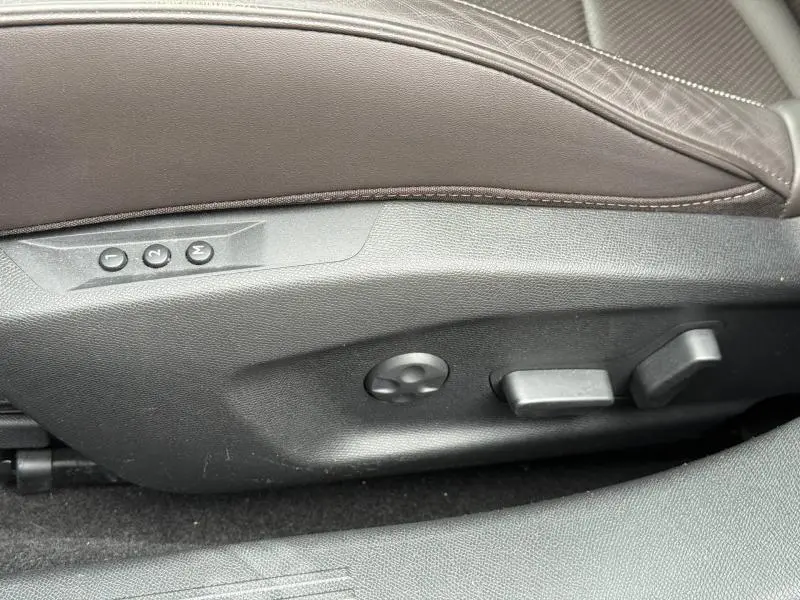 Détail des commandes de réglage électrique du siège conducteur en cuir marron dans une DS4 Gris Platinium 2023.