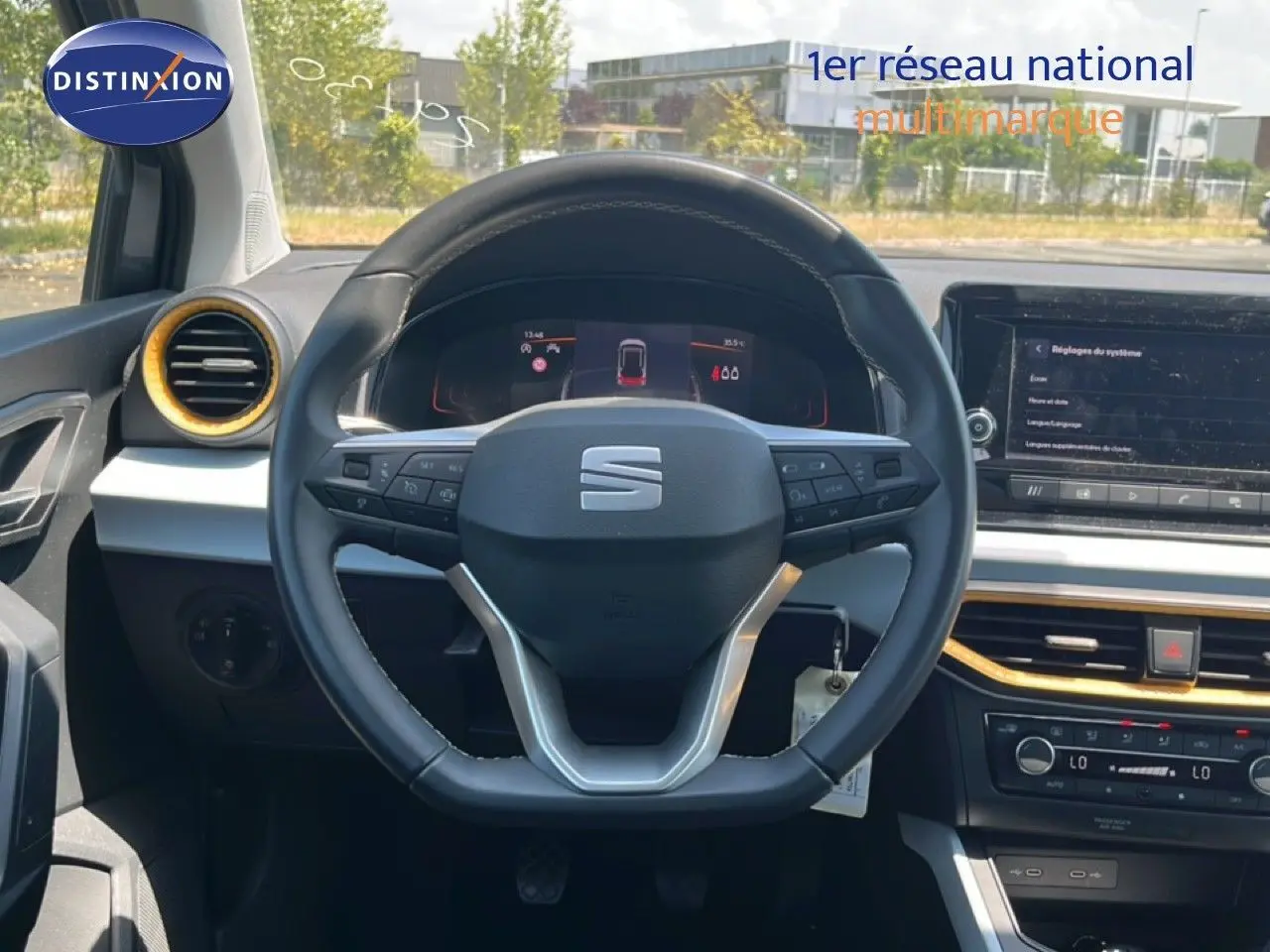 Vue intérieure centrée sur le volant noir du SEAT Arona 2026 avec détails gris et touches dorées autour des aérateurs.