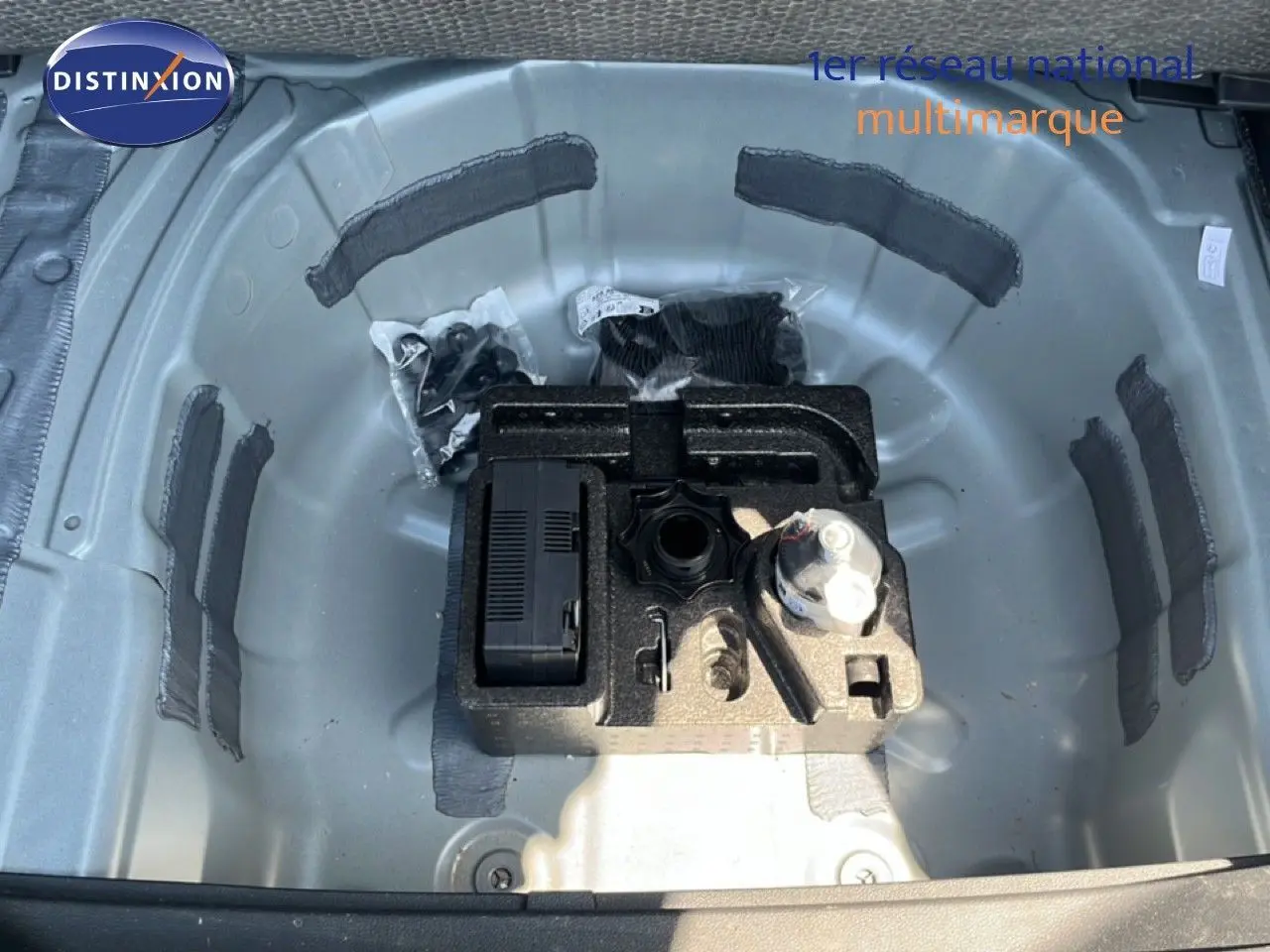 Gros plan sur le compartiment de roue de secours gris métallique d'une SEAT Arona 2026, avec outils de bord rangés.