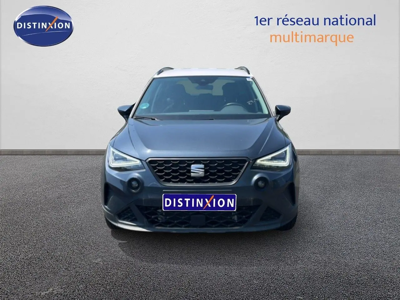 Vue avant d'une SEAT Arona gris magnetic metal avec toit blanc, mettant en valeur ses phares LED anguleux.