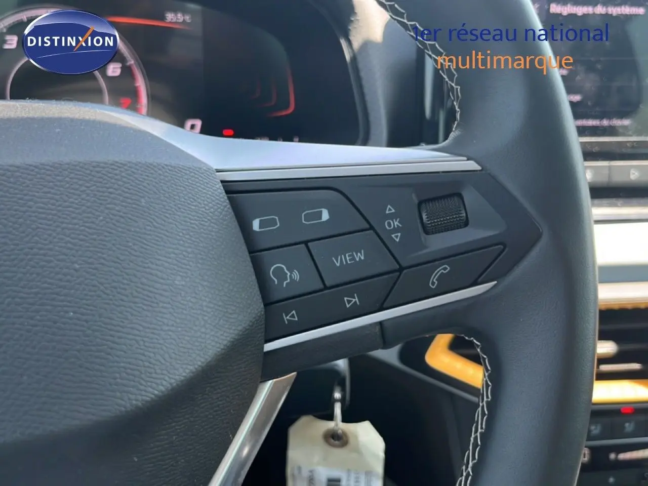 Gros plan sur le volant noir avec commandes multifonctions du SEAT Arona gris Magnetic 2026, intérieur moderne et écran digital.