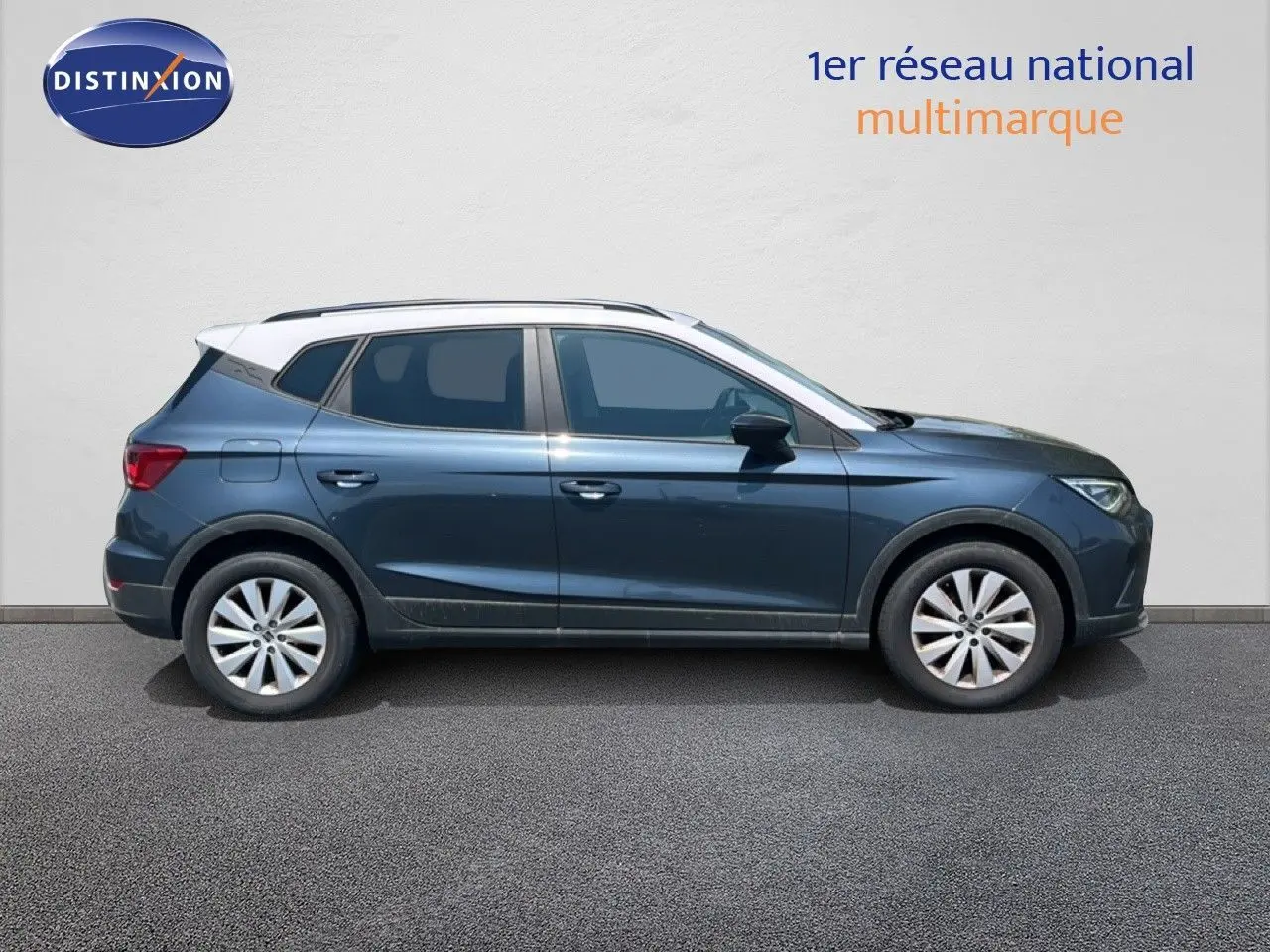Vue de profil côté gauche d'un SEAT Arona gris Magnetic avec toit blanc, roues alliage et lignes dynamiques.