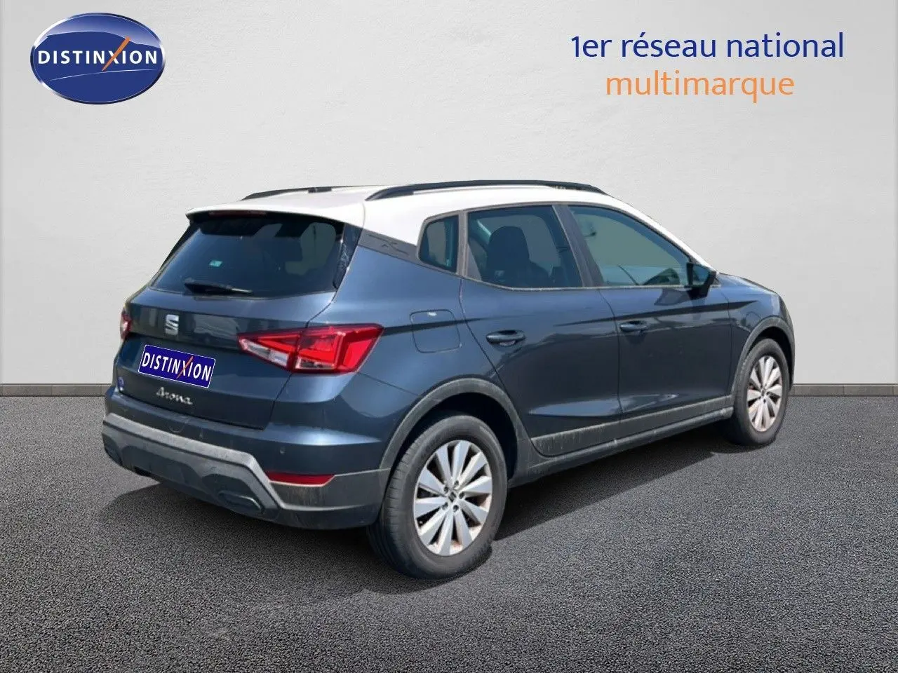Vue 3/4 arrière droite d'une SEAT Arona gris magnetic avec toit blanc, mettant en valeur son design compact et ses feux arrière LED.