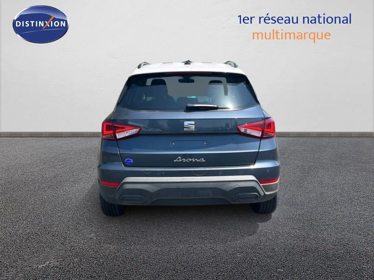 Vue arrière d'un SEAT Arona gris Magnetic avec toit blanc, mettant en valeur les feux arrière et le logo central.