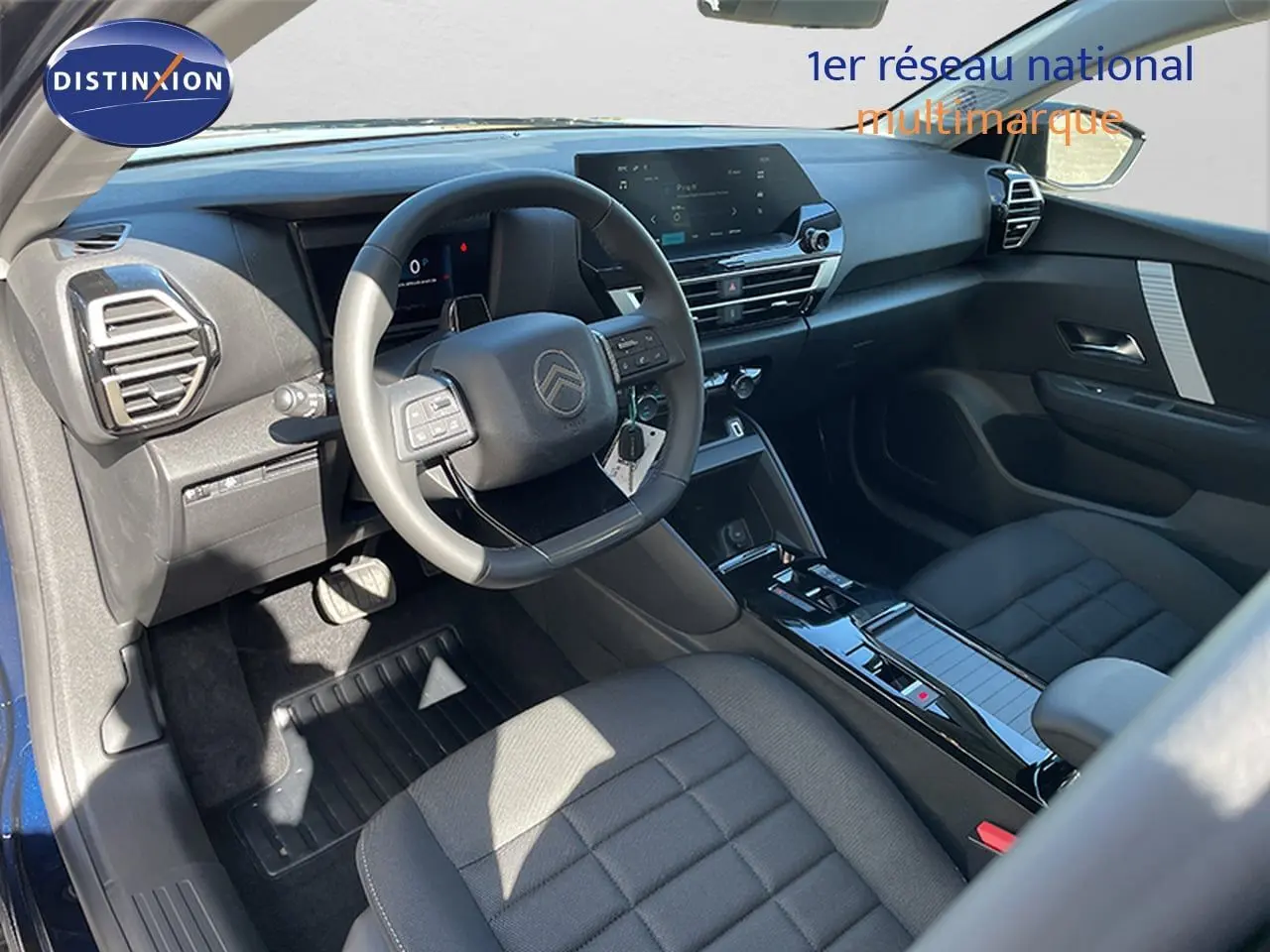 Intérieur de la Citroën C4 Hybrid 145ch, vue côté conducteur montrant le tableau de bord et les sièges noirs.