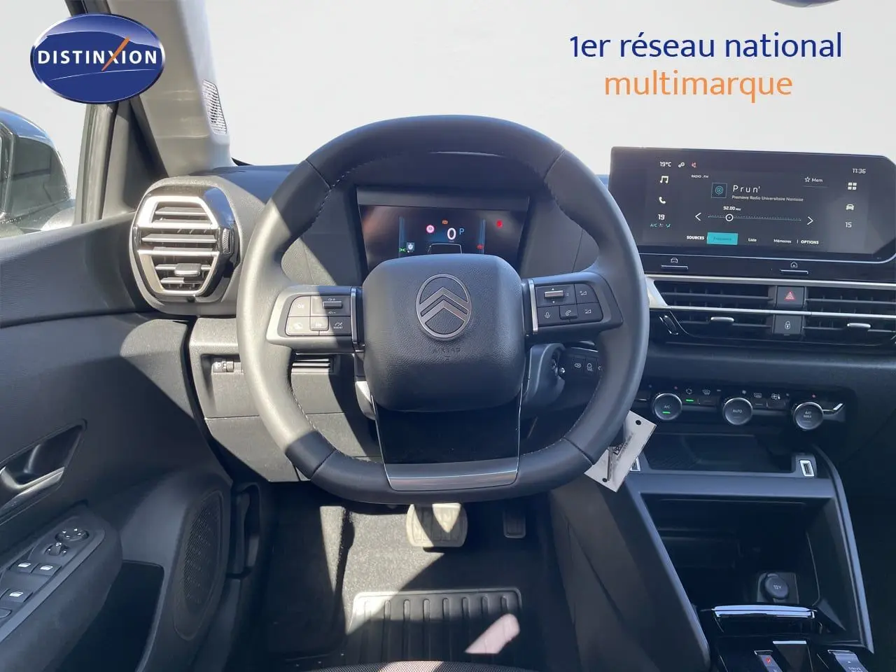 Vue intérieure centrée sur le volant et tableau de bord numérique de la Citroën C4 Hybrid 145ch, ambiance noire moderne.