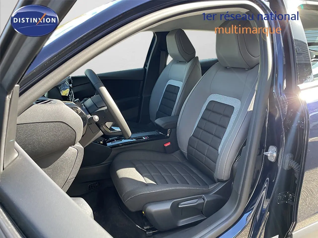 Vue intérieure côté conducteur de la Citroën C4 Hybrid 145ch bleu Eclipse, avec sièges tissu et cuir gris et noir.