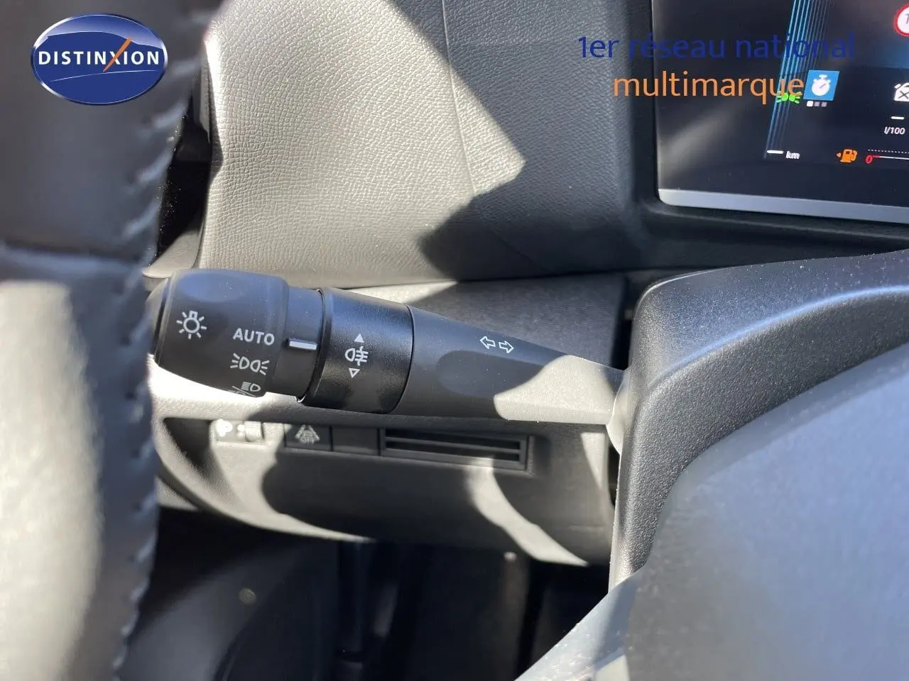 Détail du commodo d’éclairage à gauche du volant dans l’habitacle d’une Citroën C4 bleu Eclipse Metal 2026.